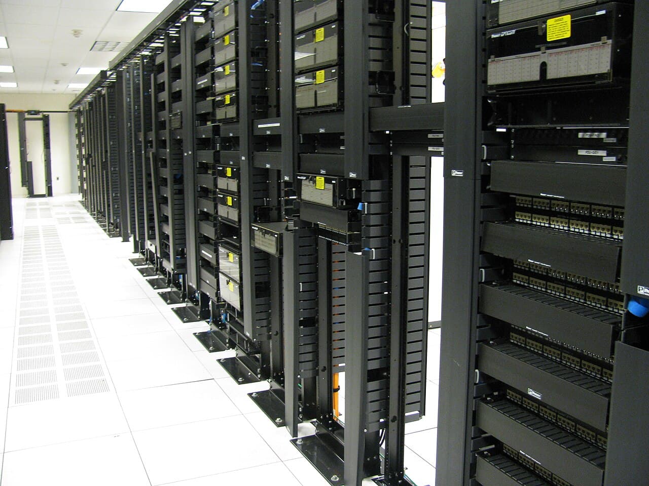 Rows of network racks and structured cabling in a modern data center aisle